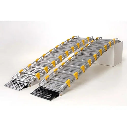 Two metal vehicle ramps with yellow safety guards and black rubber tread sections, shown on a clean white studio background.