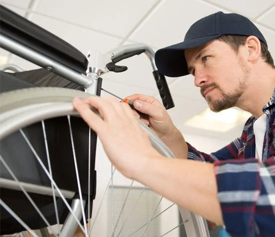 Man working on a bicycle wheel inside a building